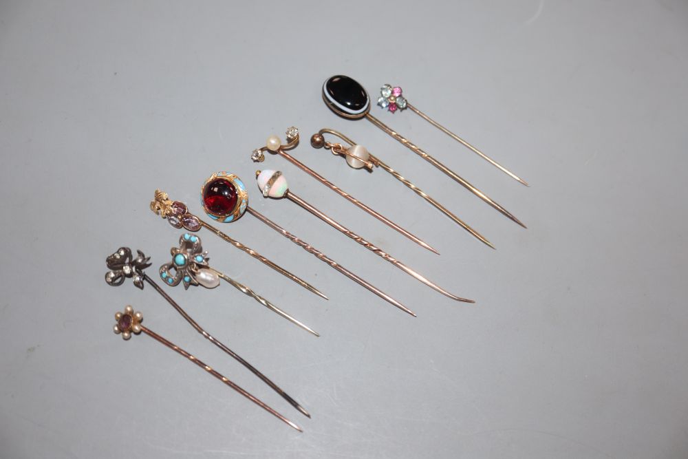 Ten assorted 19th century and later yellow metal and gem set stick pins, including garnet and enamel and banded agate,